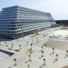 Hotel Gołębiewski Pobierowo kiedy otwarcie? Nowoczesny hotel w kształcie piramidy, wciąż w budowie, z basenami i terenami zielonymi.